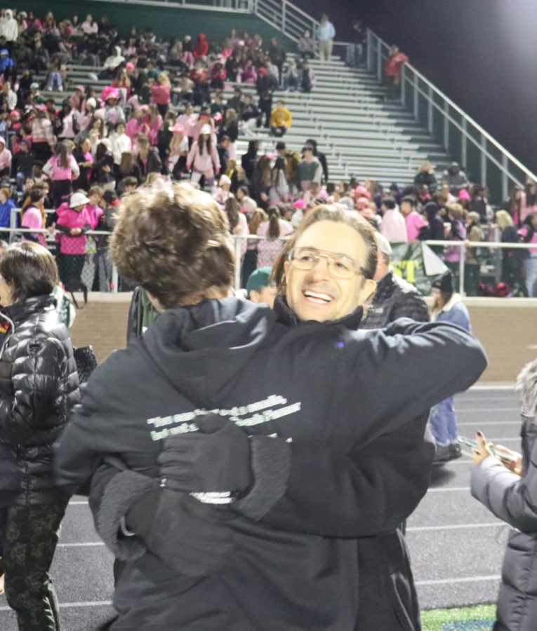 Senior Logan Edelheit shares a tight hug with his dad, Craig Edelheit, after exiting their halftime recognition on the football field on October 22.