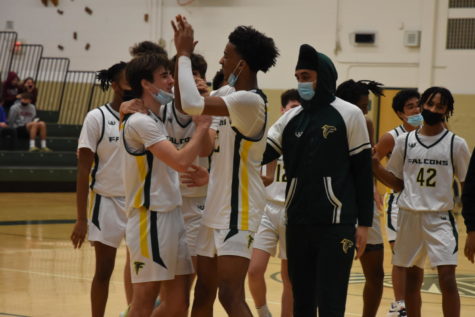 The Groves basketball team celebrates their win over rival Seaholm with junior guard Jack Abbott after he scored a game-winning layup. “It was so fun playing this game. Good sportsmanship between Groves and Seaholm and a close game is a regular occurrence for us,” Abbott said.
