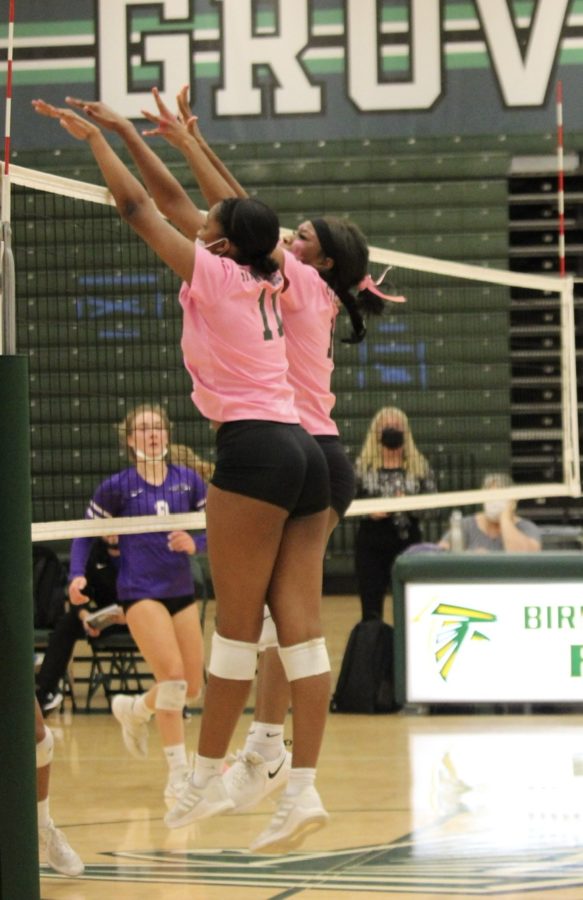 Seniors Lauren Sample and Dajah Mines rise up for a block against Bloomfield Hills outside hitter on October 21. They both go up at the same time to block off the hitters swing to help the back row players. Its a lot better for two people to go up rather than one person because with two people it helps take off a lot of power from the hitters swing.