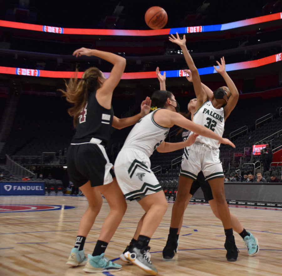 Sophomore Naveah Cochran-McKay jumps to obtain the ball before her Seaholm opponent at the Little Caesars Arena as part of the Court of Dreams program on December 19. “Theres definitely a ton of intensity because Seaholm is our rival. This pushes us to do better because we want to show them up,”  Cochran-McKay said.