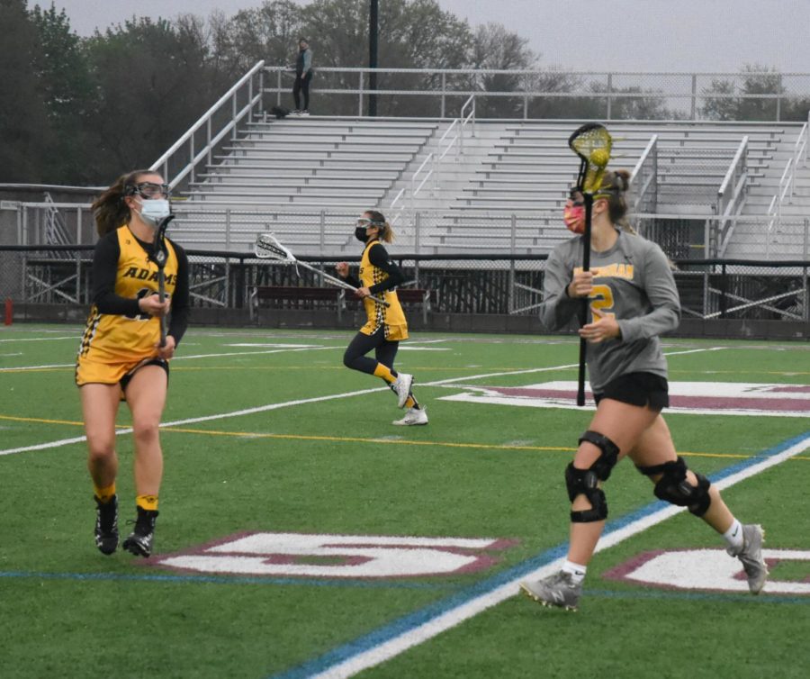 With the ball in her possession, junior Girls Birmingham Lacrosse player Madee McBride navigates her way through the field as her Rochester Adam’s opponent approaches from her right. Madee went on to score three goals for the BWLAX during Thursday, May 20’s playoff game against Grosse Pointe South. During the Rochester Adams game on May 3, the BWLAX team won by a longshot with a 20-1 win.