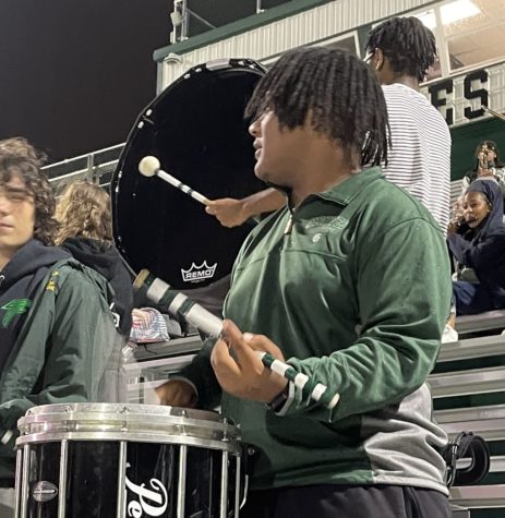 Senior Norman Hurns, drumline section leader, leads the band through the Groves annual Powder Puff football game. Even in the pouring rain, Hurns and the band give up their Friday nights to be at the Stadium for every varsity home game. Hurns and the band dazzles the audience with their musical talent.