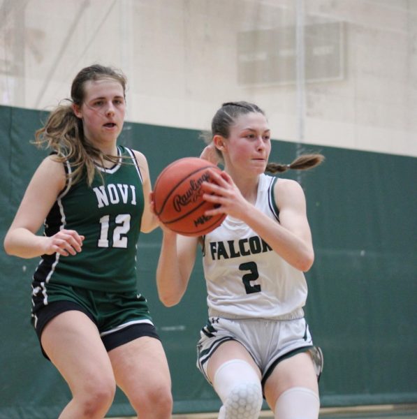 Groves point guard Jacey Roy drives past a Novi defender, setting up for a pass out to the wing. Roy has been on the varsity team since a freshman, and plays a key role in Groves rotation.