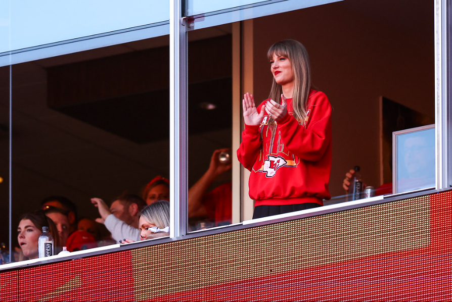Taylor Swift celebrating at a Chiefs game, unaware of the cameras facing her.
