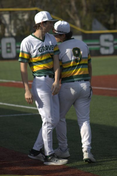 Varsity Baseball player, Daniel Fisher #9, walking back to the field with a teammate at the top of a new inning.
