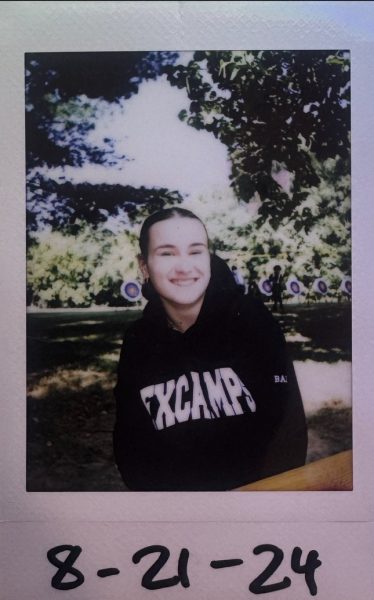 A polaroid of Baity Wagner at Experience Camps, sitting at a picnic table.