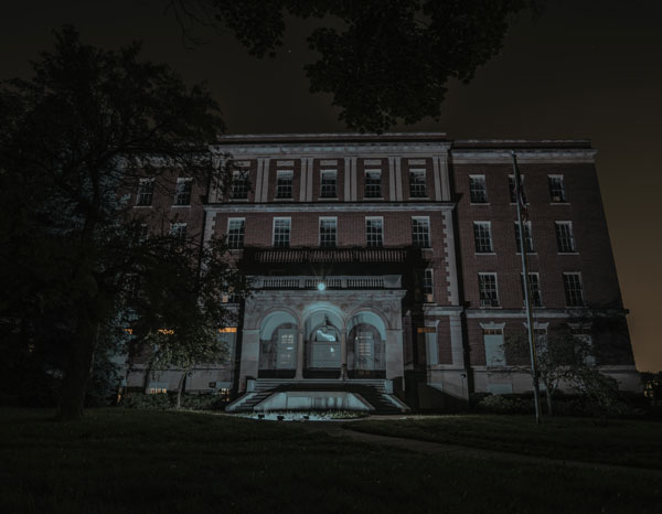 Photographed by Eloise Asylum and presented on their website [https://eloiseasylum.com/wp-content/uploads/2023/11/ELOISE-HISTORICAL-TOURS.jpg], the haunted attraction building is pictured at night.