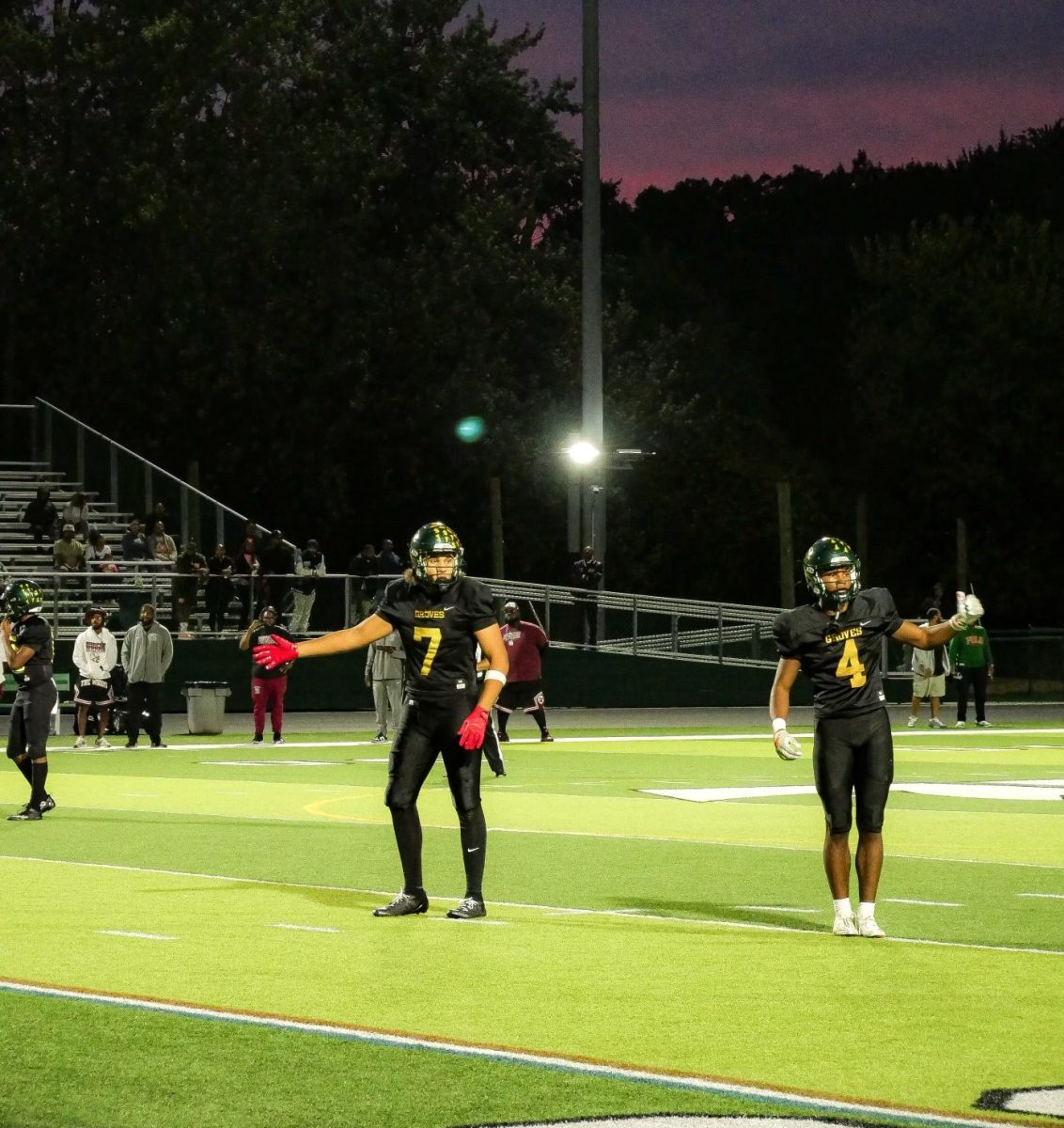 The Groves Offense is getting ready, with Noah Woods and Noah Sanders signaling to their coach. 