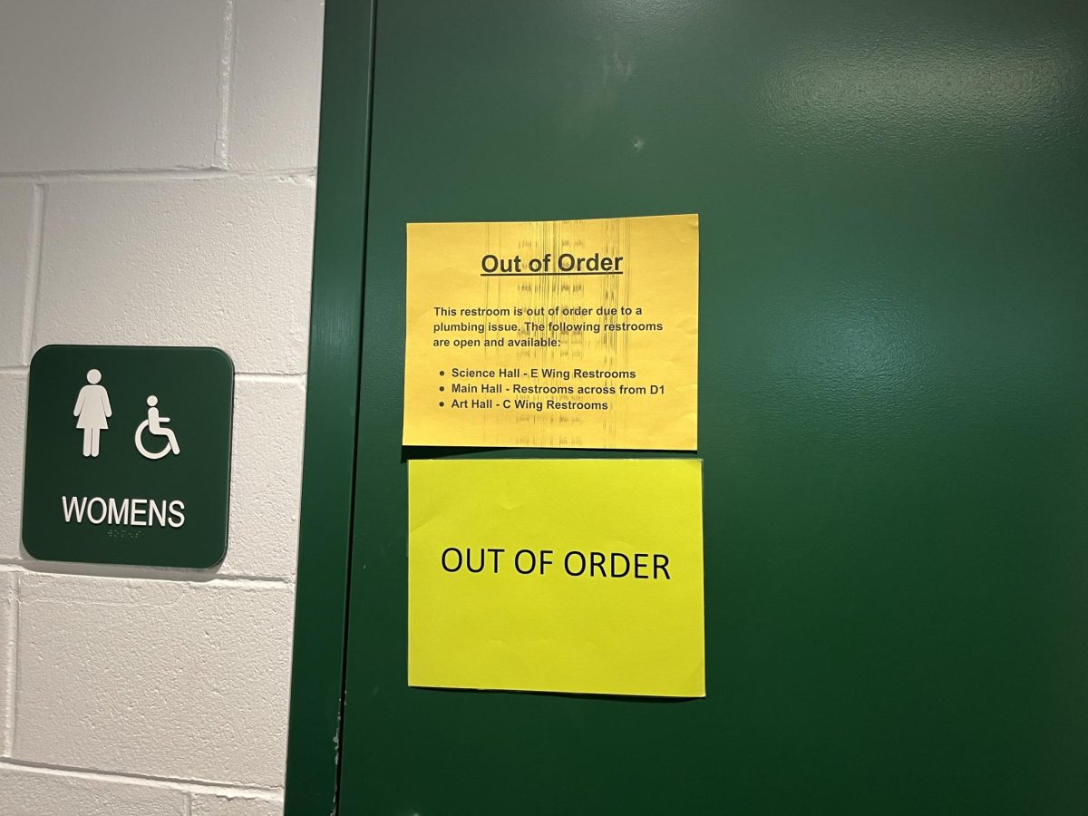 Door of the main bathroom at Groves, currently adorned with two bright yellow “OUT OF ORDER” signs. One of the signs below provides a list of open bathrooms – only three.