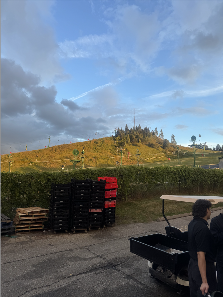 The back alley of Pine Knob Music Theatre's VIP Lounge "The Ivy," riddled with crates, a golf cart and one of Wagner's coworkers. The alley overlooks Pine Knob's adjacent skill hills.