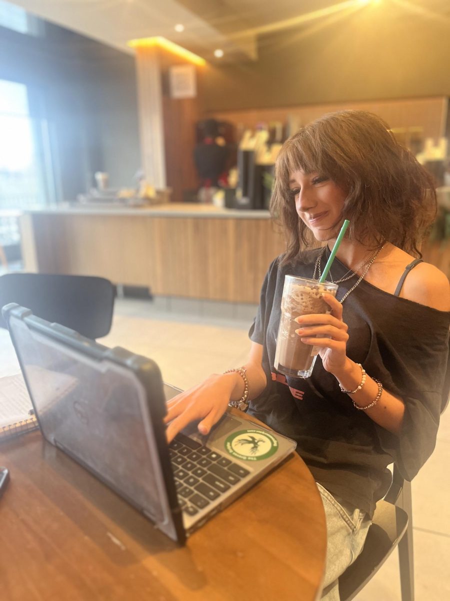 Groves senior Sofia Alrawi enjoying a drink and working on her school work during blended learning time.