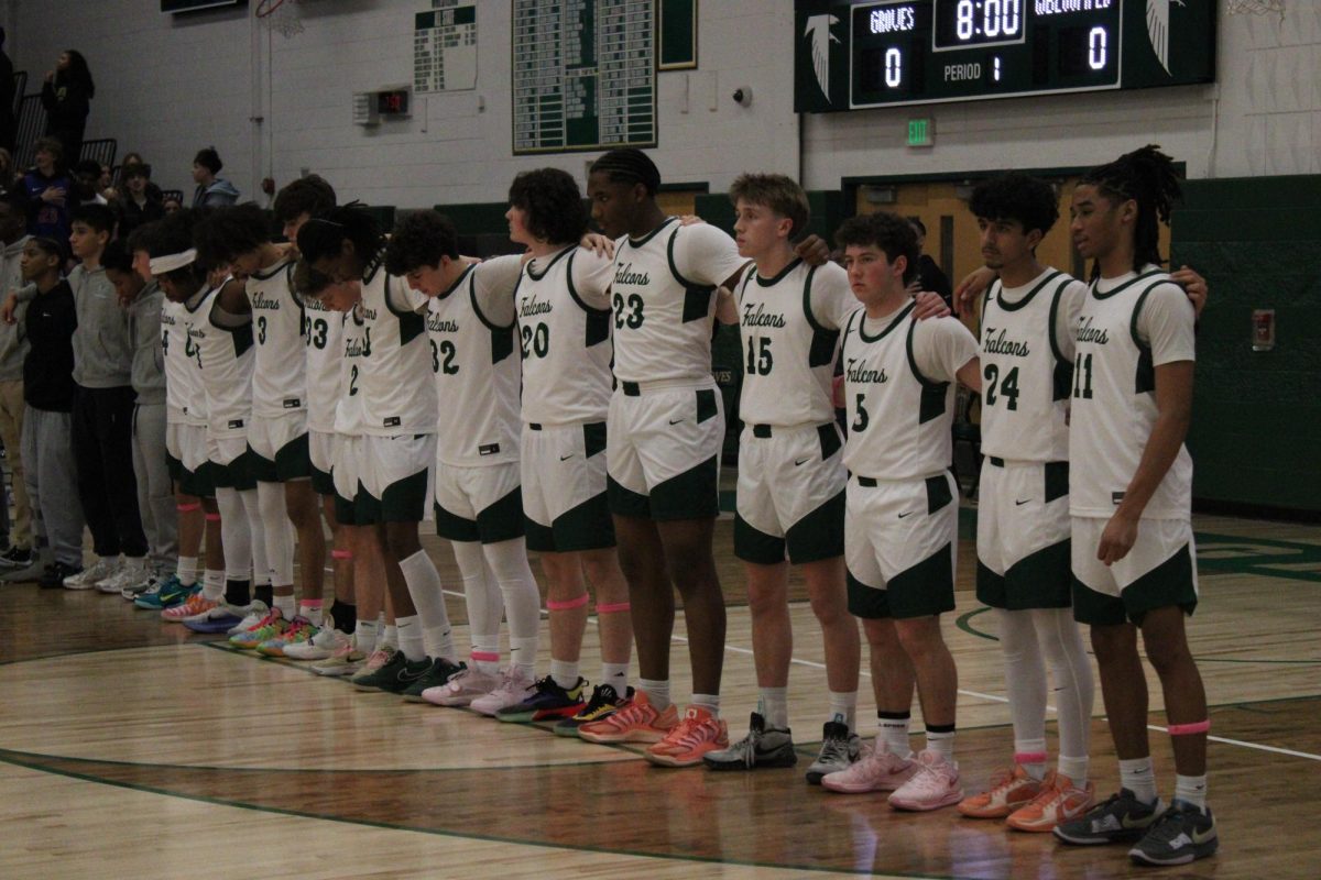 Groves Falcons basketball team stands for the national anthem in game against West Bloomfield high school.