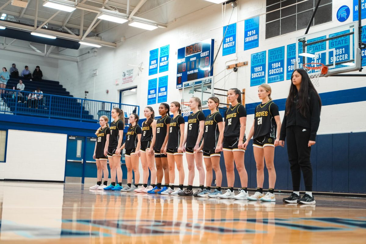 A photo of the Groves Girls Basketball team lined up on their side of the court before a game.